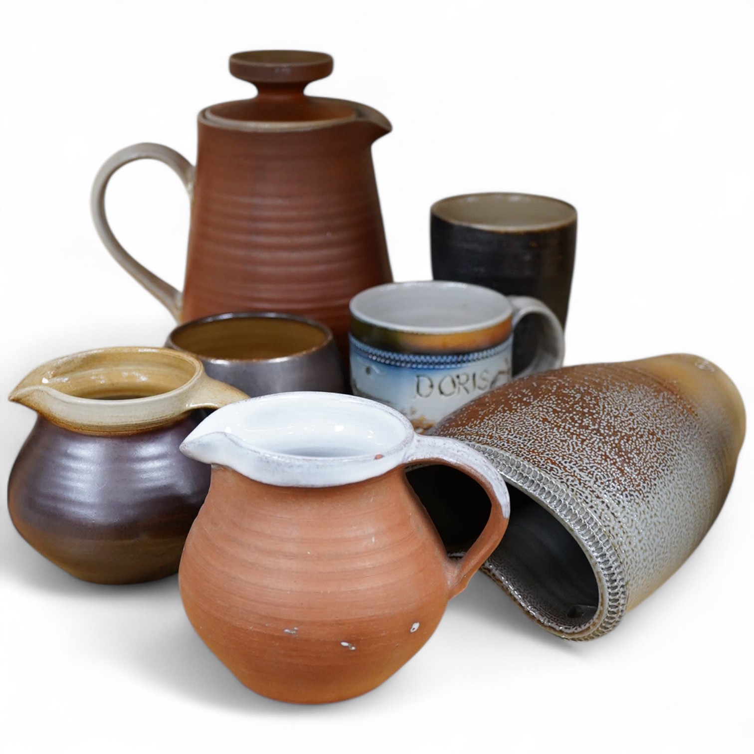 Guy Sydenham (1916-2005), studio pottery comprising a wall pocket, two jugs, Doris (sister-in-law) mug, coffee pot and cover, and a beaker, largest 19cm high
